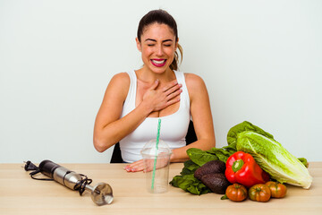 Young caucasian woman preparing a healthy smoothie with vegetables