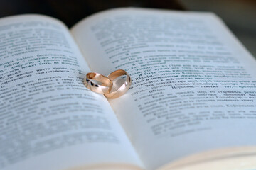 Fototapeta premium wedding rings on the book with a text