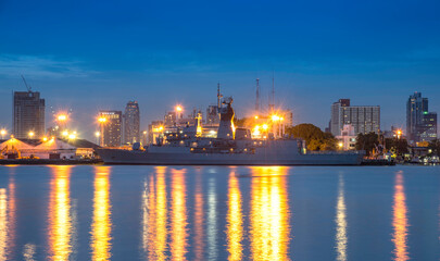 Warship docked at the port of Bangkok in the evening.