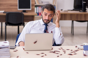 Young male employee and too many cockroaches in the office