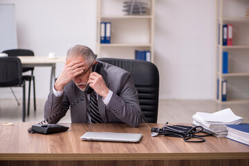 Aged male employee suffering at workplace