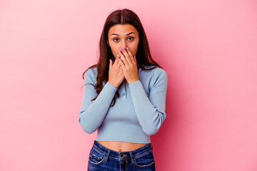 Young Indian woman isolated on pink background shocked, covering mouth with hands, anxious to discover something new.