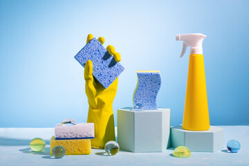 Creative still life with supplies for cleaning or housekeeping on podiums over blue...