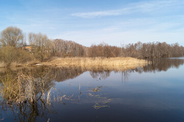 Spring landscape with a river against a blue sky