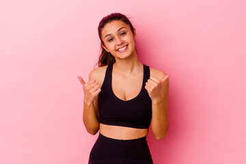 Young sport Indian woman isolated on pink background raising both thumbs up, smiling and confident.