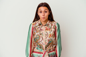 Young Indian woman isolated on white background shrugs shoulders and open eyes confused.