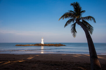 Khao Lak lighthouses on a small island at Nang Thong Beach in front of a coconut tree in Khao Lak, Phang Nga Province, Thailand