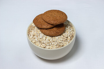 Oatmeal cookies on a plate with oatmeal on a white background. Diet food. Light breakfast