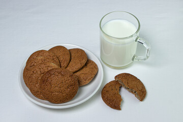 A glass of milk and oatmeal cookies on a white background. Diet food. Light breakfast