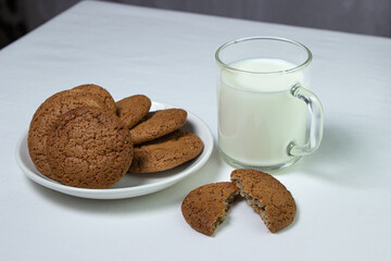 A glass of milk and oatmeal cookies on a white background. Diet food. Light breakfast