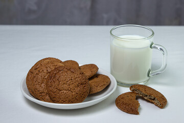 A glass of milk and oatmeal cookies on a white background. Diet food. Light breakfast