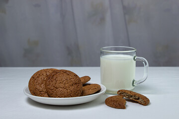 A glass of milk and oatmeal cookies on a white background. Diet food. Light breakfast