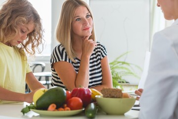 Cute boy and professional dietitian preparing a diet eating plan