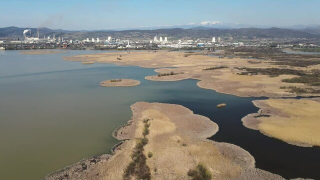 Aerial view of Ramnicu Valcea city in Romania with mountains, Olt river and a power plant