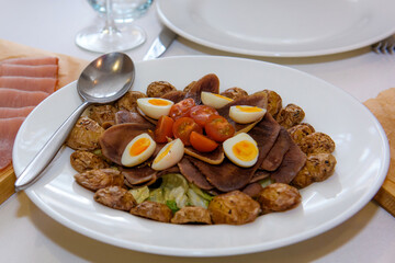 Cold cuts of meat on a plate. Appetizer of cold cuts on the dining table.