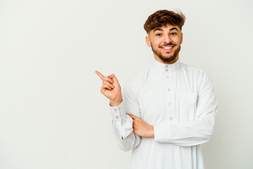 Young Moroccan man wearing a typical arab clothes isolated on white background smiling cheerfully pointing with forefinger away.