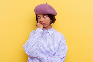 Young mixed race woman wearing a beret isolated on yellow background who feels sad and pensive, looking at copy space.