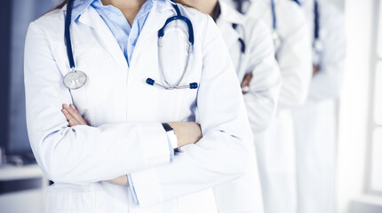 Group of modern doctors standing as a team with arms crossed in hospital office. Medical help, insurance in health care, best desease treatment and medicine concept