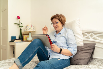 An elderly woman happily talking via video communication