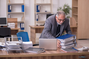 Old male employee unhappy with excessive work in the office