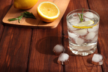 A glass of water with ice, lemon and rosemary. Refreshing summer drinks. Detox concept
