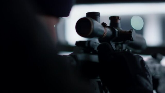 Sniper preparing to shoot with automatic rifle. Male soldier loading army weapon