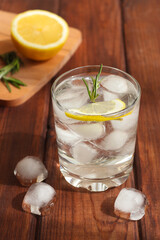 A glass of water with ice, lemon and rosemary. Refreshing summer drinks. Detox concept. Close-up