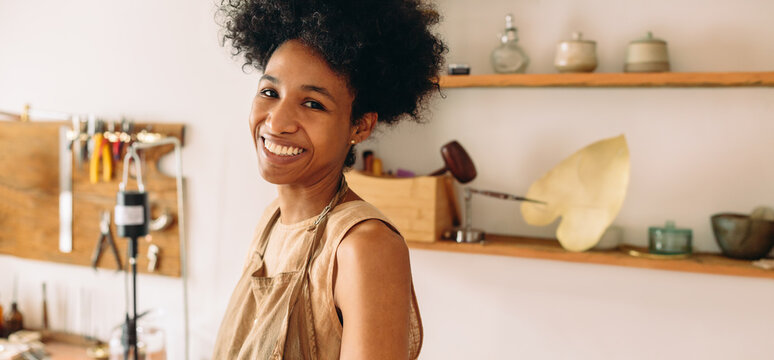 Happy jewelry artist in studio