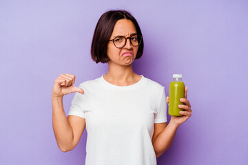 Young mixed race woman holding a healthy smoothie isolated on purple background showing a dislike...