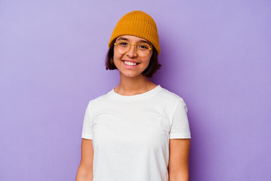 Young mixed race woman wearing a wool cap isolated on purple background happy, smiling and cheerful.