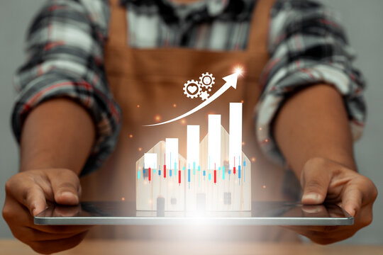 Carpenter holding tablet and wood house model is on screen tablet and illustration stock chart for new hight business real estate. Property hight sale graph dashboard with key performance indicators.