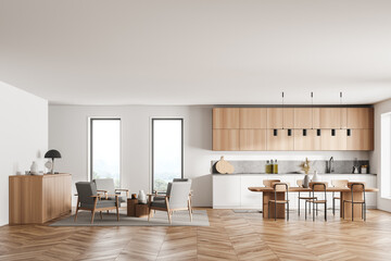 Fototapeta na wymiar Stylish interior of bright and white modern kitchen room with dining table and chairs. Armchairs livingroom zone open space.