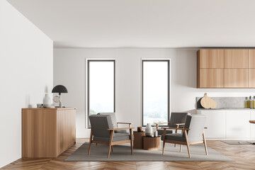 Stylish interior of bright and white modern kitchen room. Armchairs livingroom zone open space.