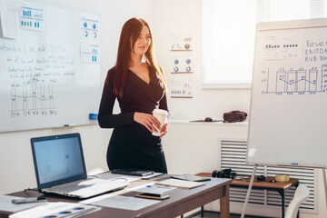 Obraz na płótnie Canvas Female office worker standing near white board.