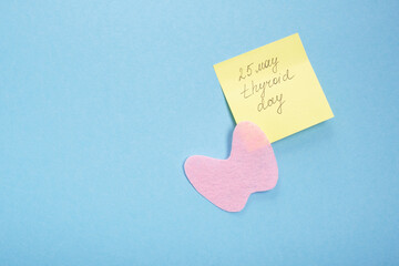 silhouette of the thyroid gland cut out of pink felt and a yellow sticker with the inscription...