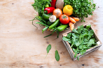 Fresh Vegetables in basket on wooden table. Top view.