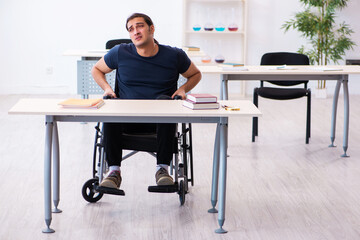 Young male student in wheel-chair preparing for exams