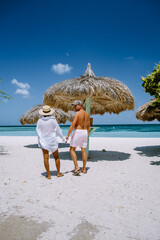Palm Beach Aruba Caribbean, white long sandy beach with palm trees at Aruba Antilles, couple man...