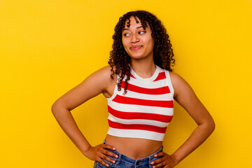 Young mixed race woman isolated on yellow background dreaming of achieving goals and purposes