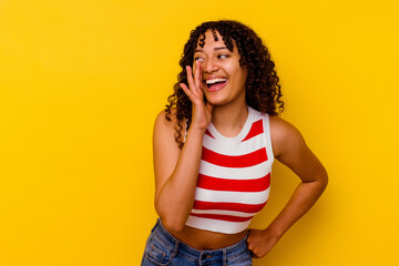 Young mixed race woman isolated on yellow background shouting excited to front.