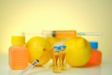 Vitamin C in ampoules. solution for injection. Health and Beauty.Organic cosmetics concept.Syringes, solution for injections, lemons fruits on a  yellow background.Strengthening immunity 