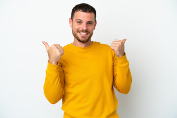 Young Brazilian man isolated on white background with thumbs up gesture and smiling