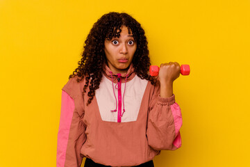 Young mixed race sport woman isolated on yellow background