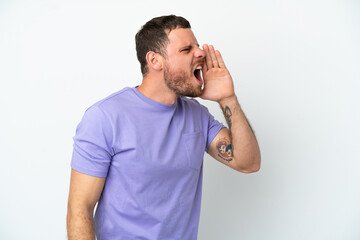 Young Brazilian man isolated on white background shouting with mouth wide open to the side