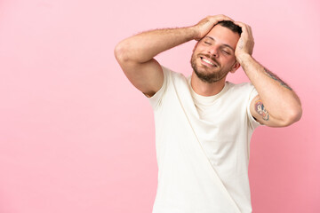 Fototapeta na wymiar Young Brazilian man isolated on pink background laughing