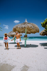 Palm Beach Aruba Caribbean, white long sandy beach with palm trees at Aruba Antilles, couple man...