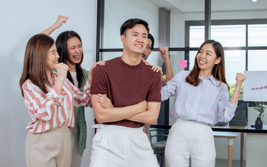 Asian handsome creative and business man wearing casual shirt, successful smiling with confidence, happiness and pride with their colleague celebrate to him, standing in indoor office or workplace.