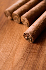 Group of brown cuban cigars on wooden background