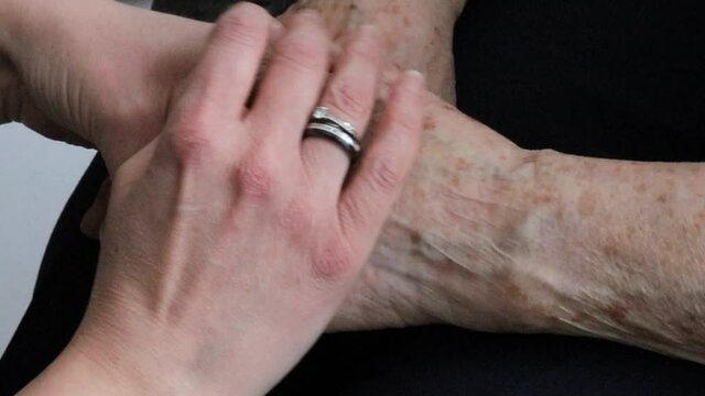 femme tenant les mains d'une grand-m&egrave;re dans les siennes