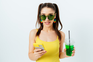 Smiling brunette young woman wearing summer yellow outfit and green sunglasses